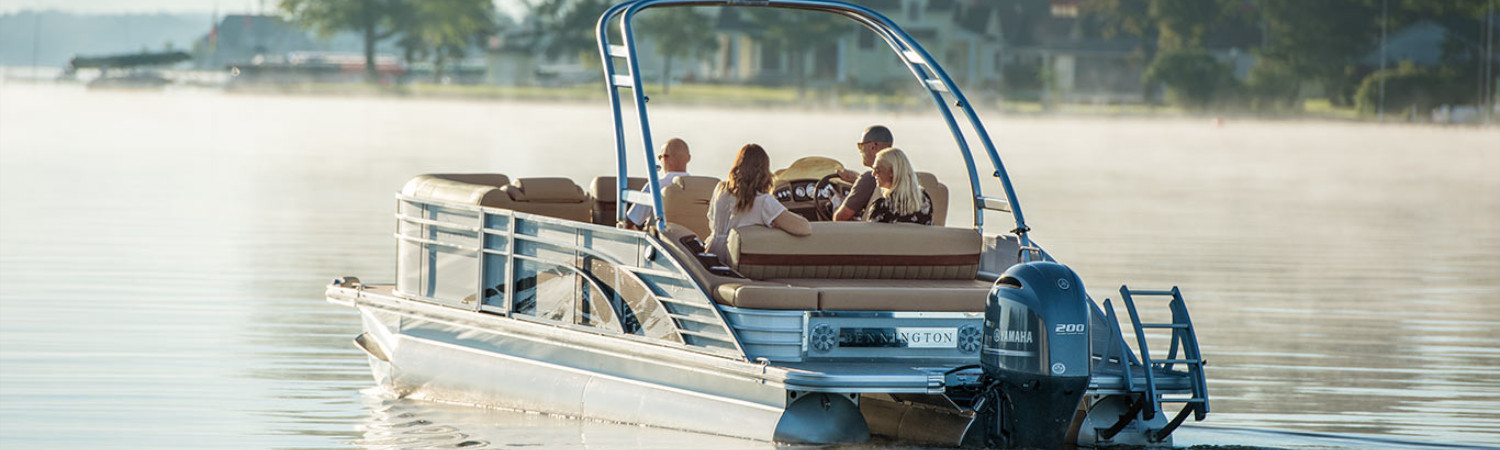 People sitting in a Bennington boat cruising down open water